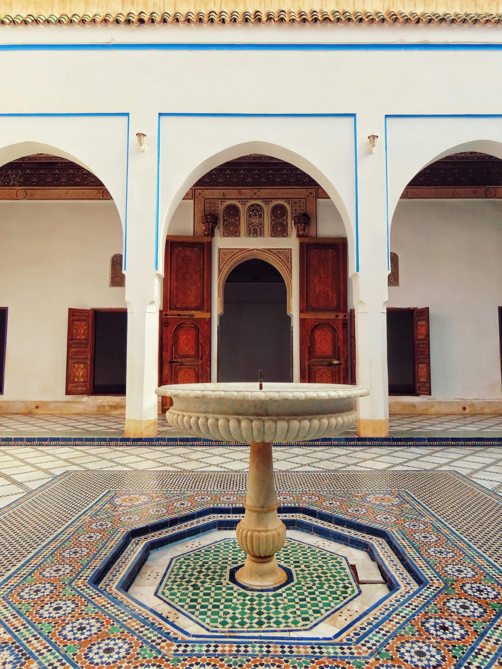 Intricate Moroccan architecture at Bahia Palace with traditional tiled flooring and fountain.